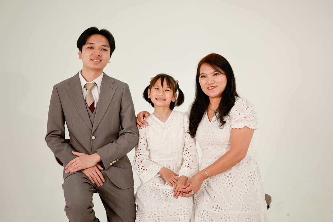 A family of three posing for a studio portrait.