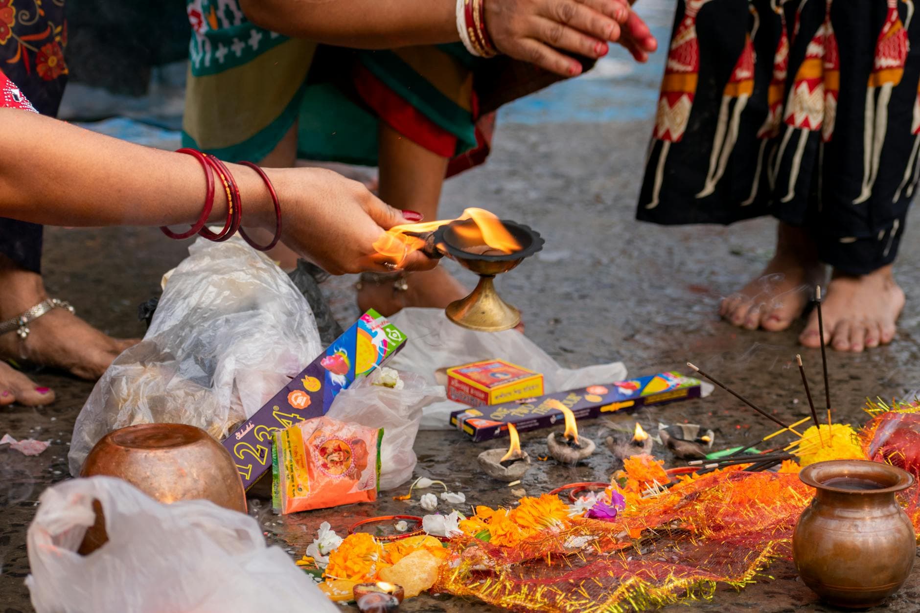 Photograph of a vibrant Hindu ritual ceremony in Kolkata, showcasing traditional offerings and cultural attire.