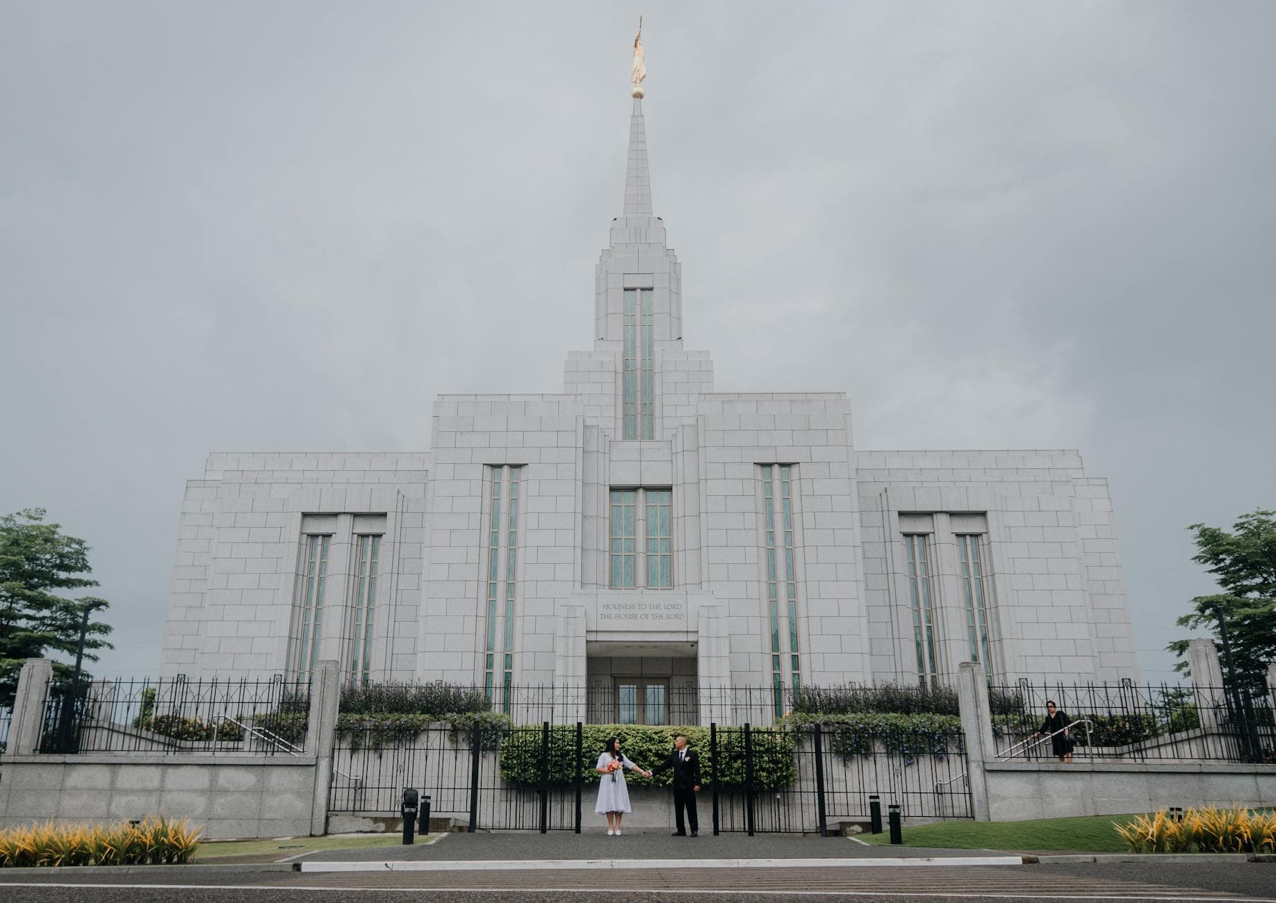 Cebu City Temple with a newlywed couple standing before its grand entrance under overcast skies.