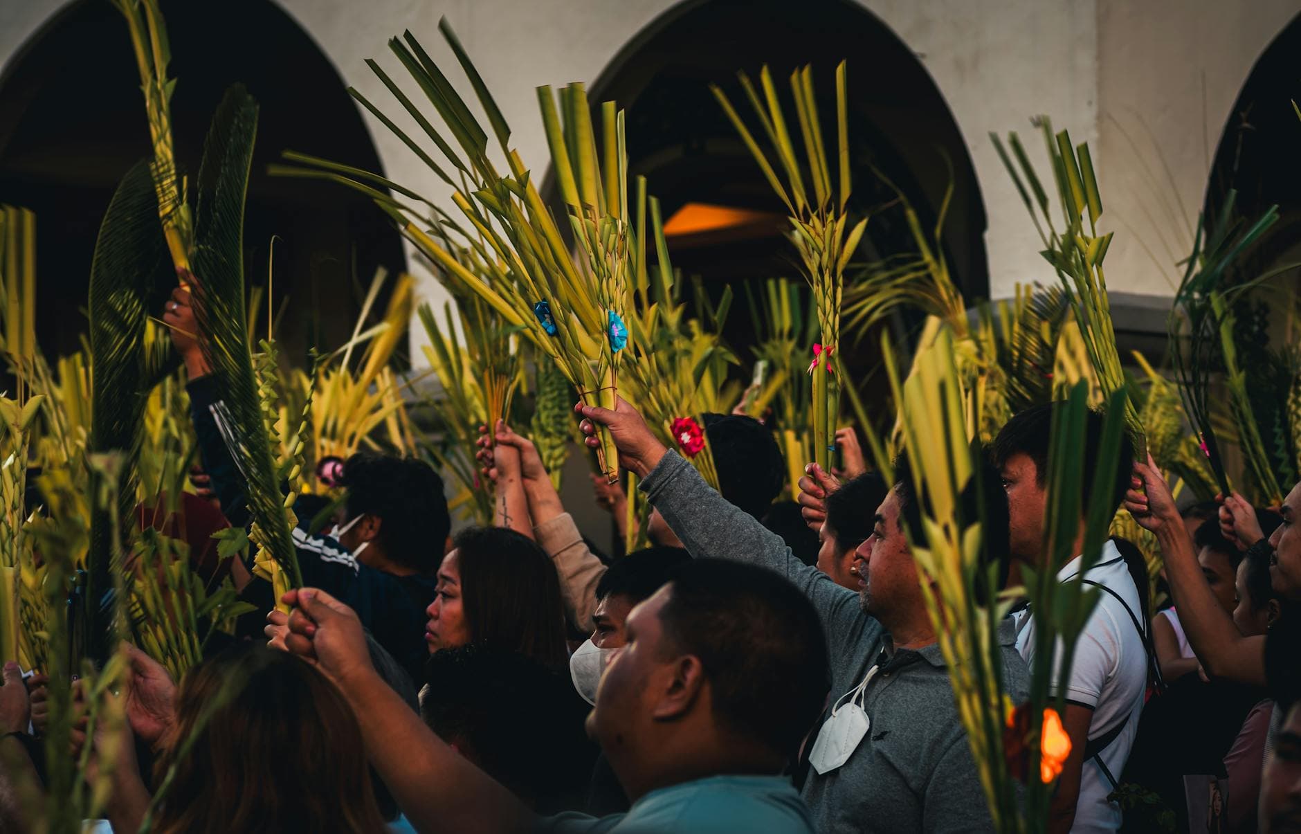 Vibrant Palm Sunday gathering in Baguio City with people holding palm fronds in a cultural celebration.
