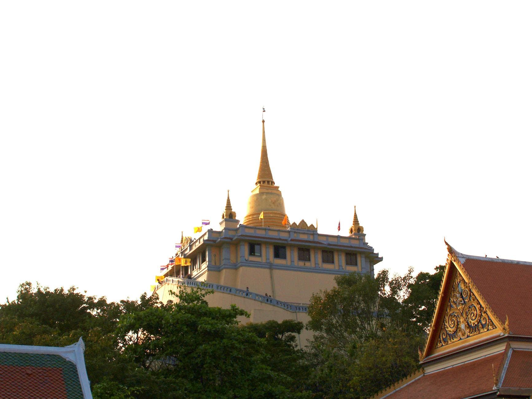 A striking view of the Golden Mount Temple in Bangkok, beautifully illuminated by the sunset.