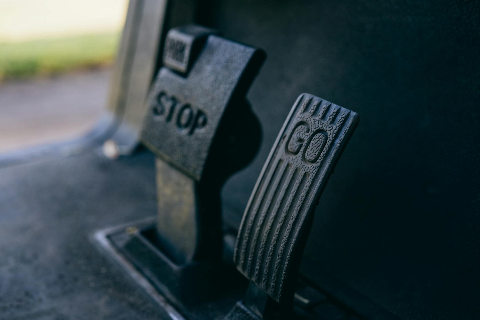 Close-up photograph of Go and Stop pedals in a vehicle, highlighting texture.