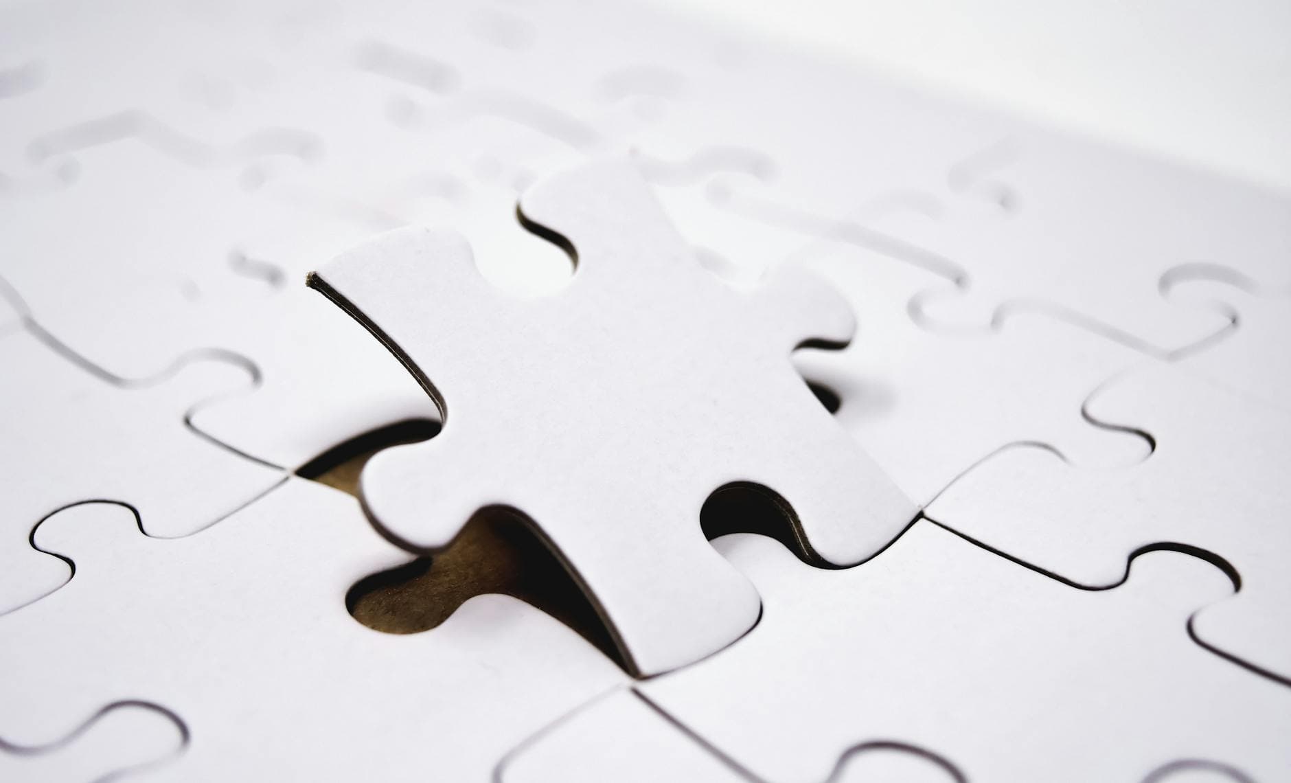 Detailed view of a single jigsaw puzzle piece being placed in a puzzle, symbolizing problem-solving.
