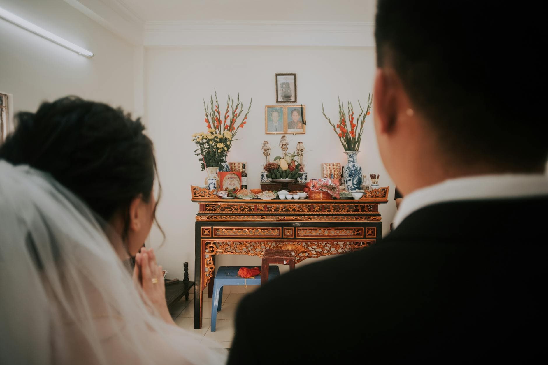 Back view of blurred groom and bride against ornamental shrine during ceremony of marriage